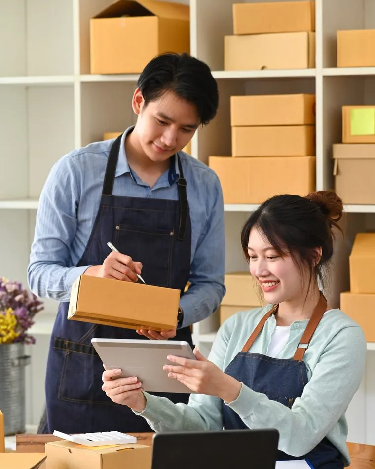 Two shopkeepers checking stock against a tablet
