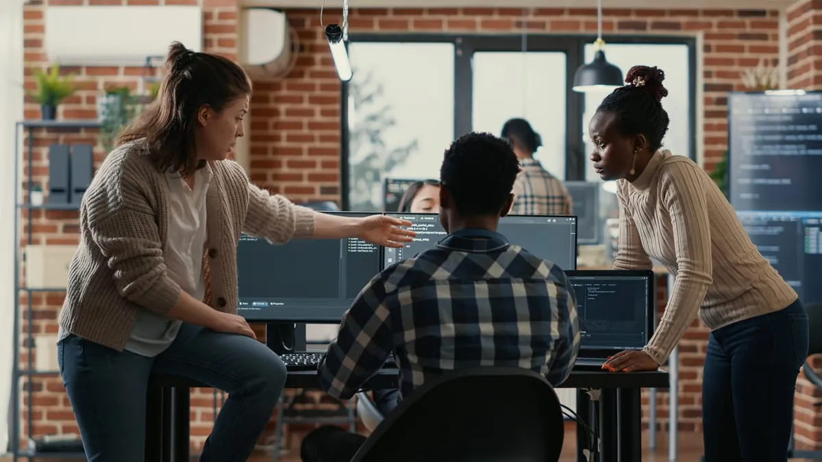 Develi engineers reviewing work together around a studio table